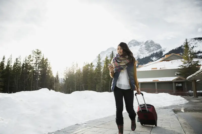 Women walking with luggage while visiting Banff in May