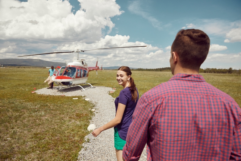 A tourist couple approaches their helicopter before their trip